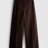 Pantalones de pierna ancha con pliegues y detalle de cinturón