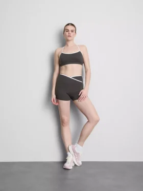 Top corto deportivo con espalda cruzada y ribetes en contraste